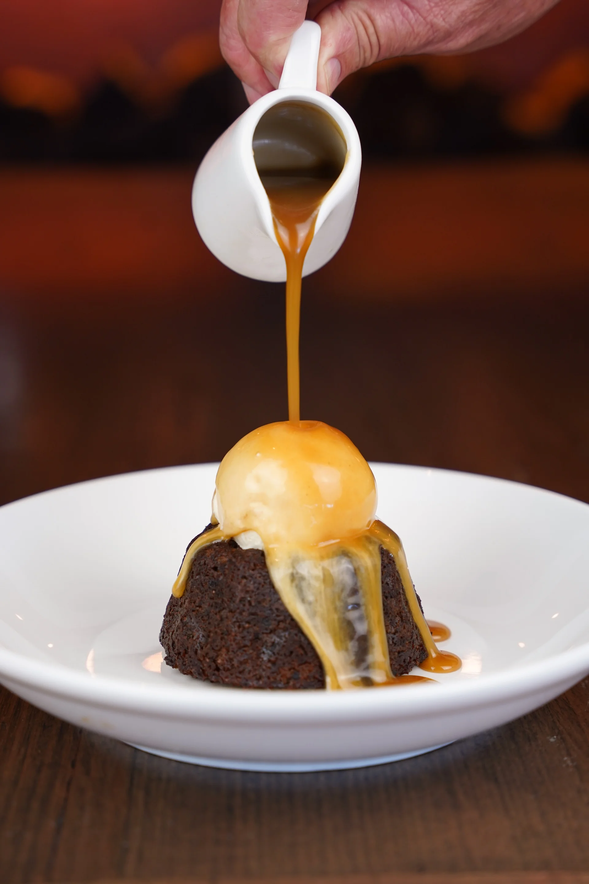 Sticky date pudding with butterscotch sauce poured over ice cream at Waterbar & Grill Steakhouse, Cairns