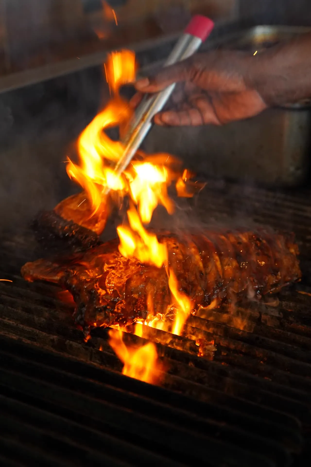 Ribs flame-grilling over open fire at Waterbar & Grill Steakhouse, Cairns