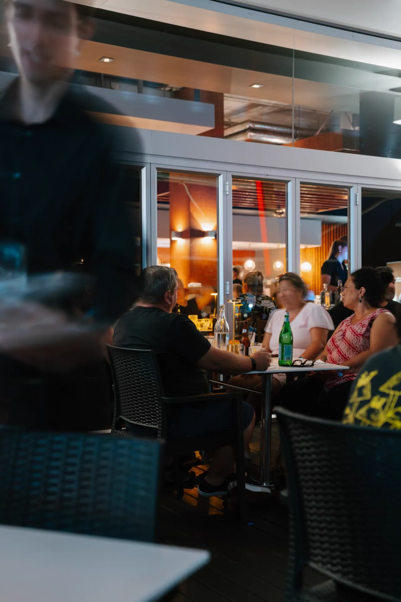 Guests dining on the deck during an evening function at Waterbar & Grill Steakhouse, Cairns